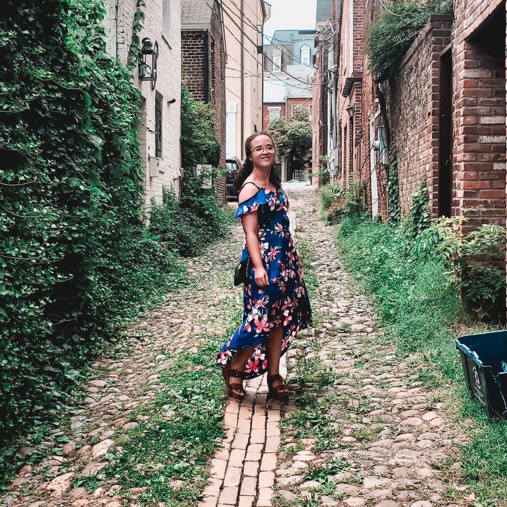 posing in a blue floral dress in an alleyway in Old town alexandria 