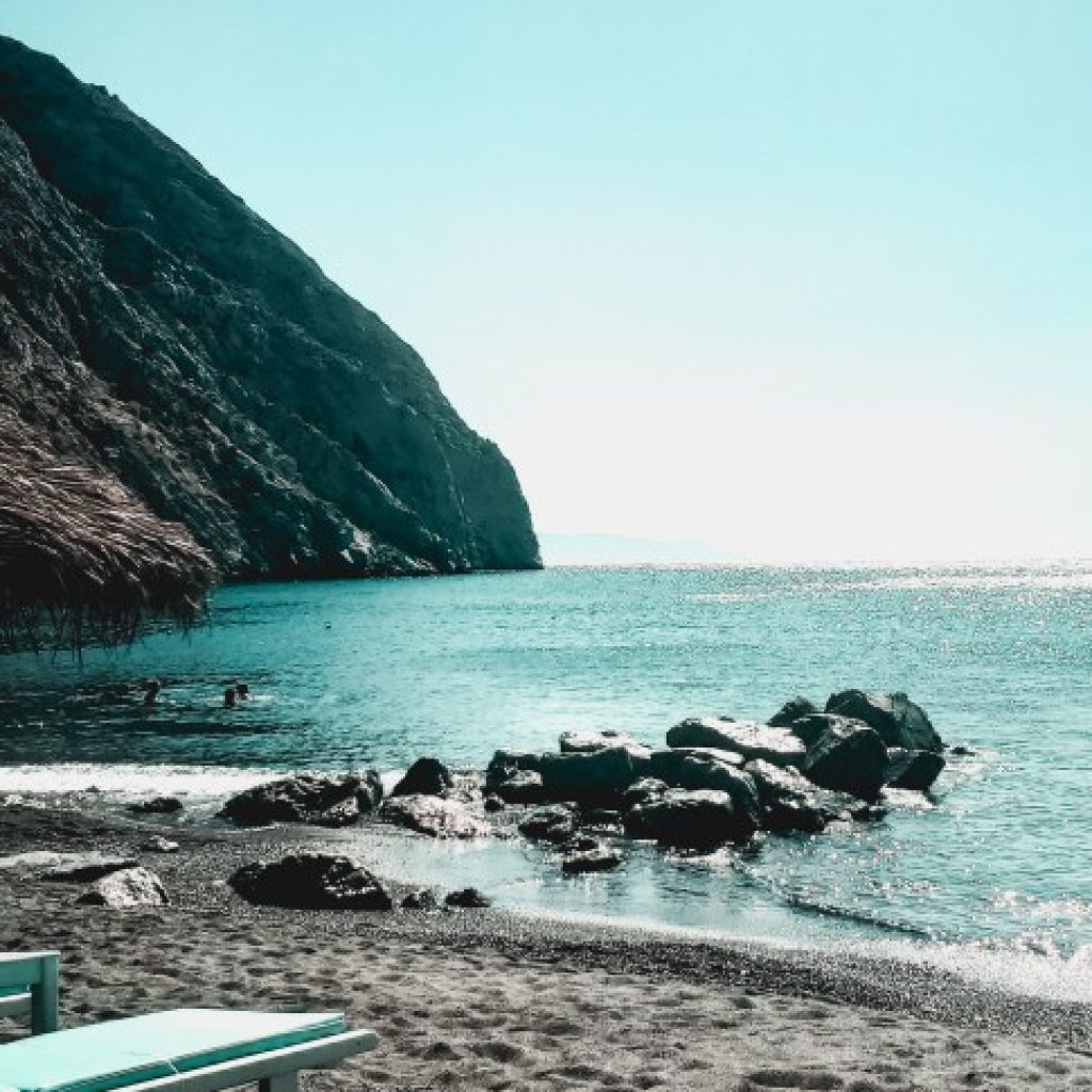 perissa beach with black sand and clear blue water
