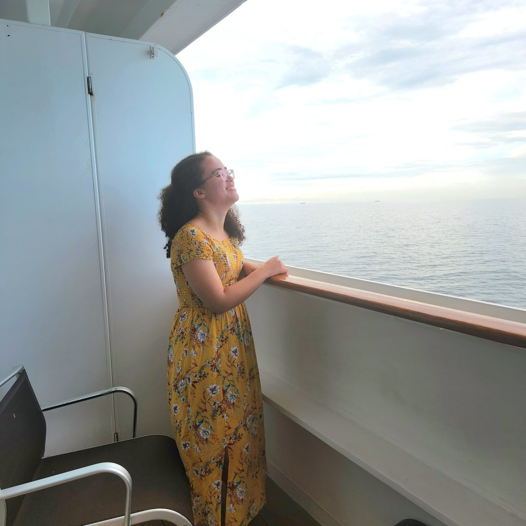 Alexis laughing on balcony with ocean view on the ship