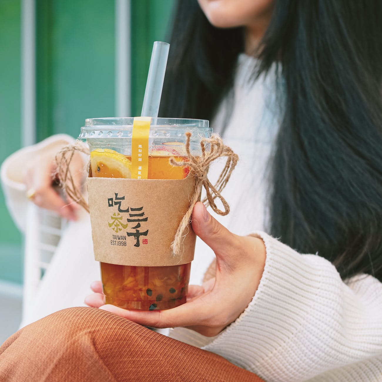 woman holding disposable cup with bubble tea