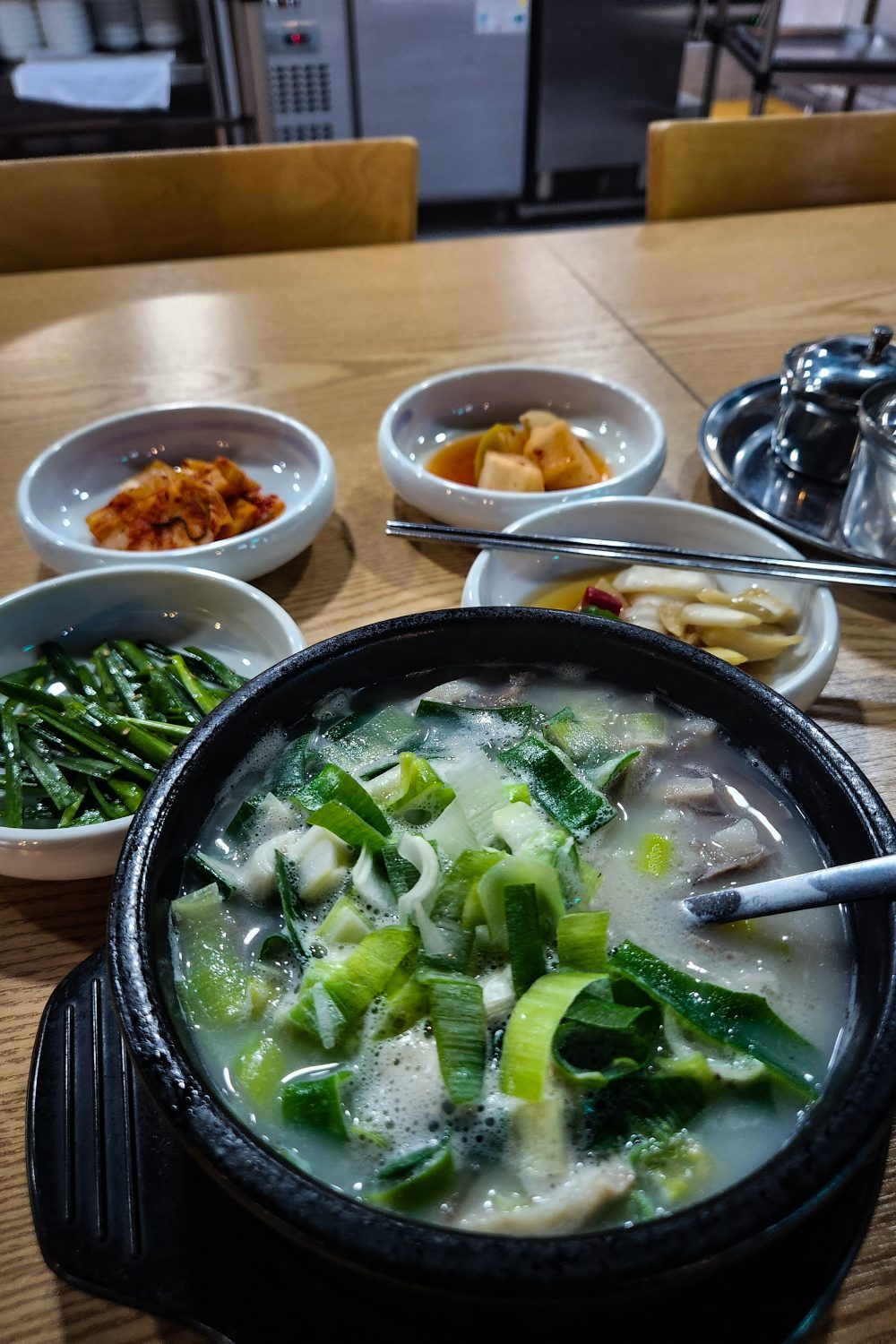 restaurant in Seoul featuring soup and side dishes like kimchi