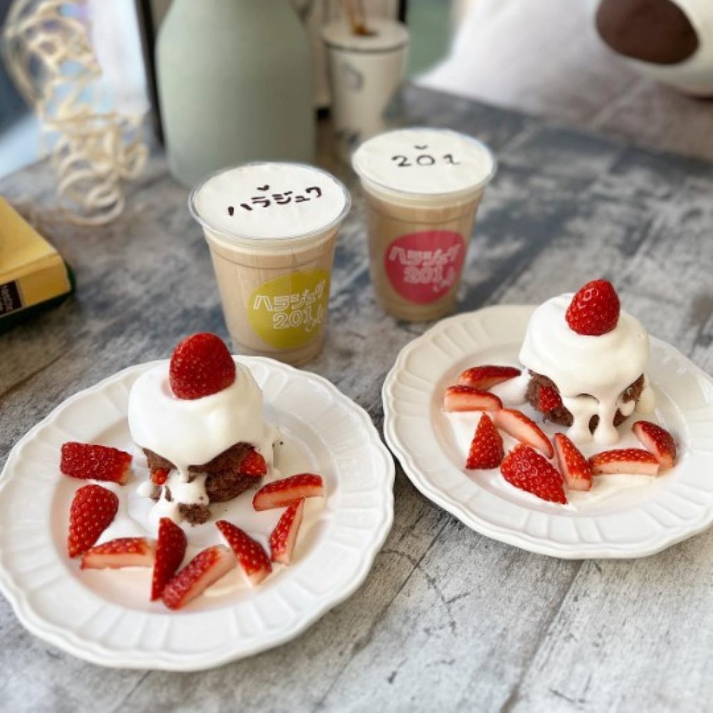 two foamy coffees and two strawberry desserts at 201 cafe in harajuku