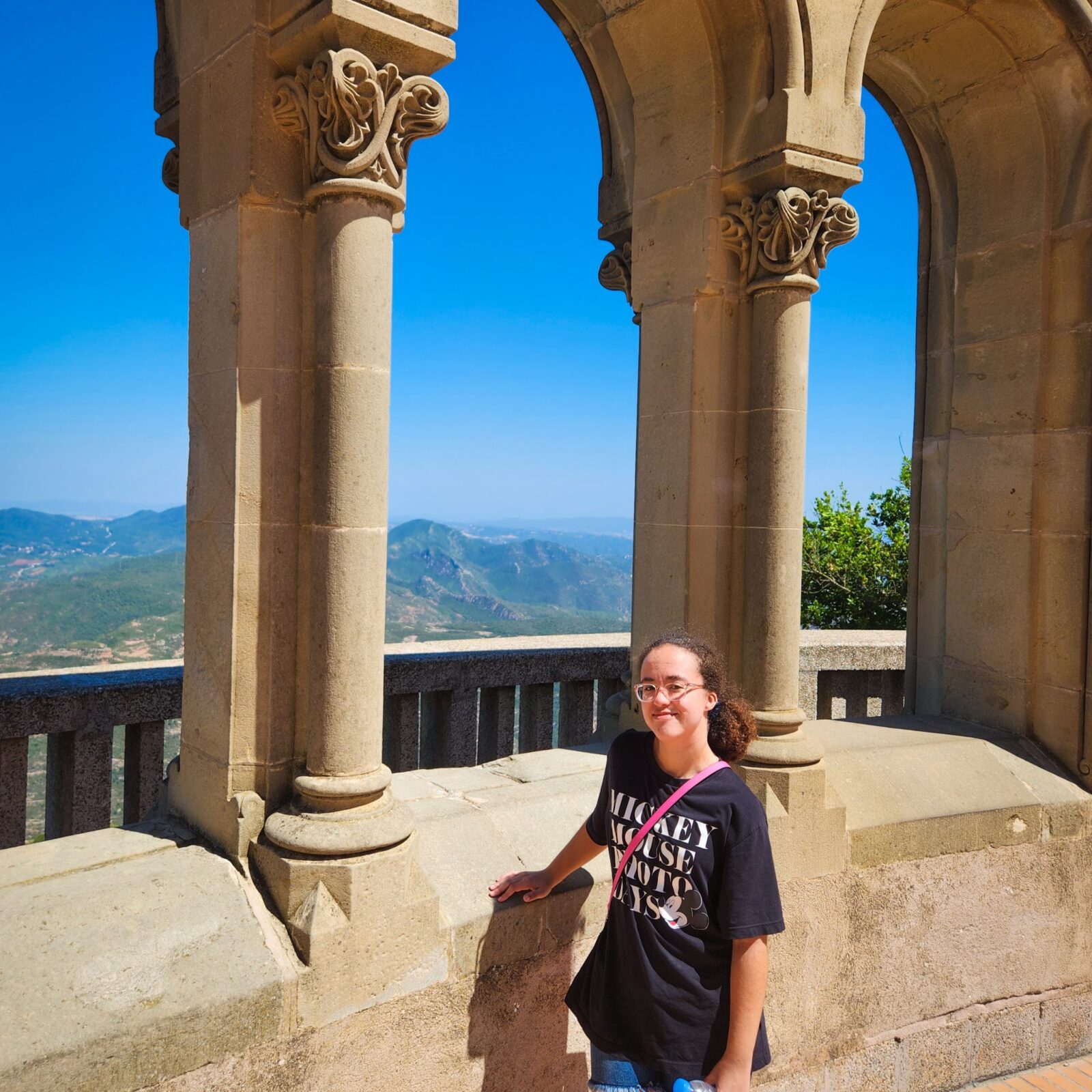 standing in front of columns with mountain views at montserrat