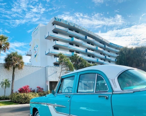 blue and white hotel with vintage car out front