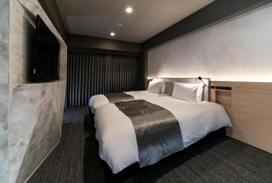 two full beds inside a boutique hotel in shinjuku with grey silk bed liner and a marble wall