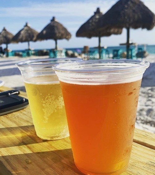 two cold alcoholic drinks with umbrellas on the beach