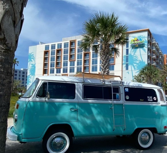 Margaritaville hotel with palm trees and blue vintage bus