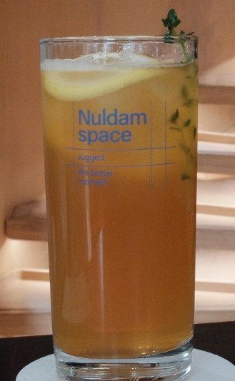a tea with lemon in a large glass with herbs