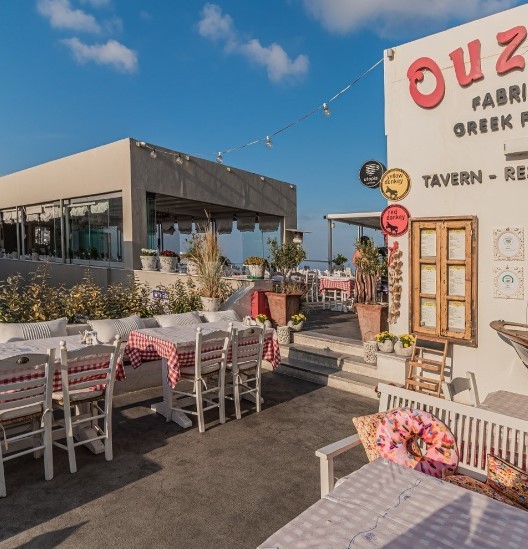 outdoor seating area at ouzeri restaurant with picnic tablecloths