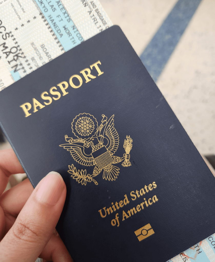 holding passport with plane ticket to japan for solo trip
