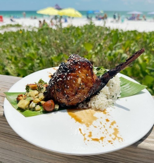 swordfish chops on top of seaweed with a view of the beach