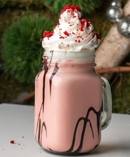 red velvet milkshake with chocolate sitting on table
