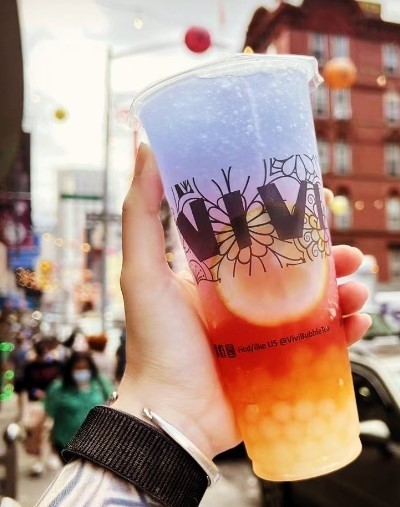 large bubble tea with purple and orange on city streets