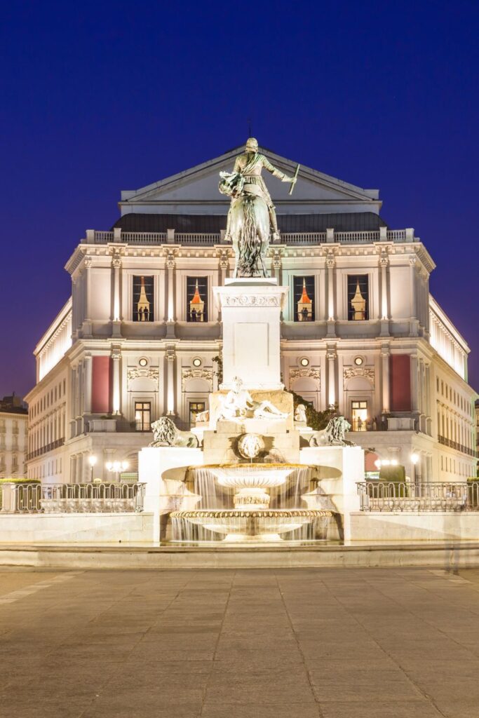 Royal Theatre with fountain and statues at night