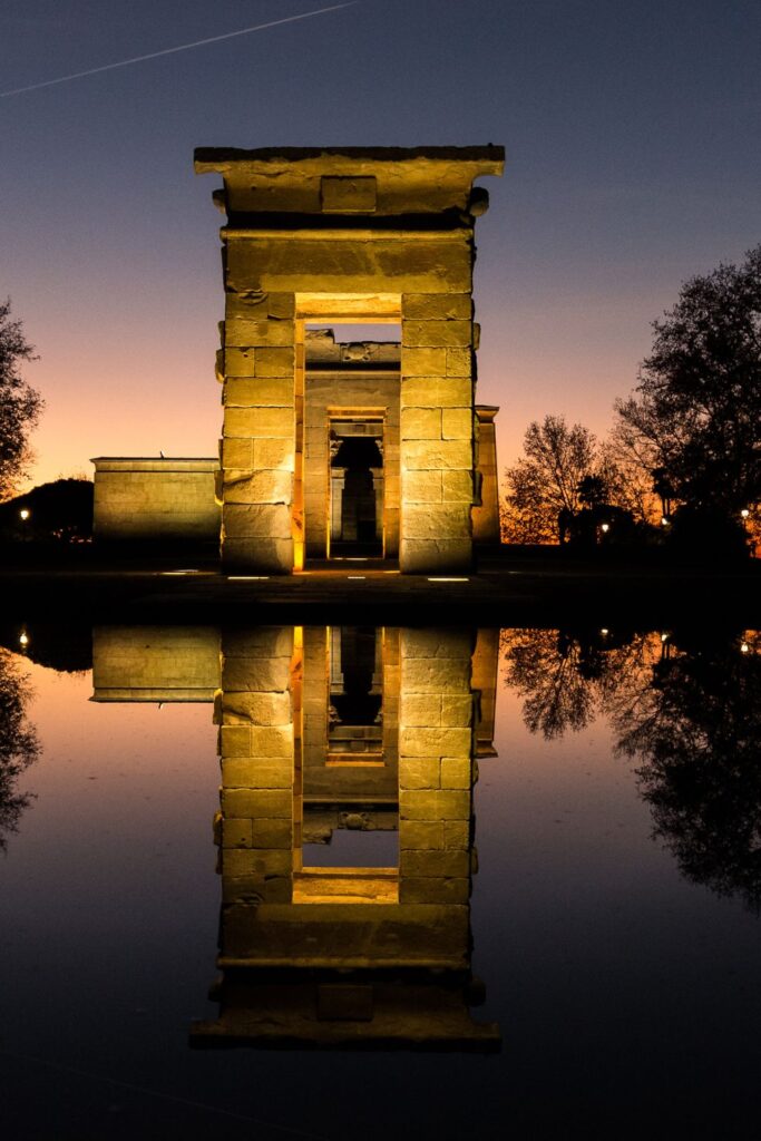 the Templo de Debod at night with a lake reflection