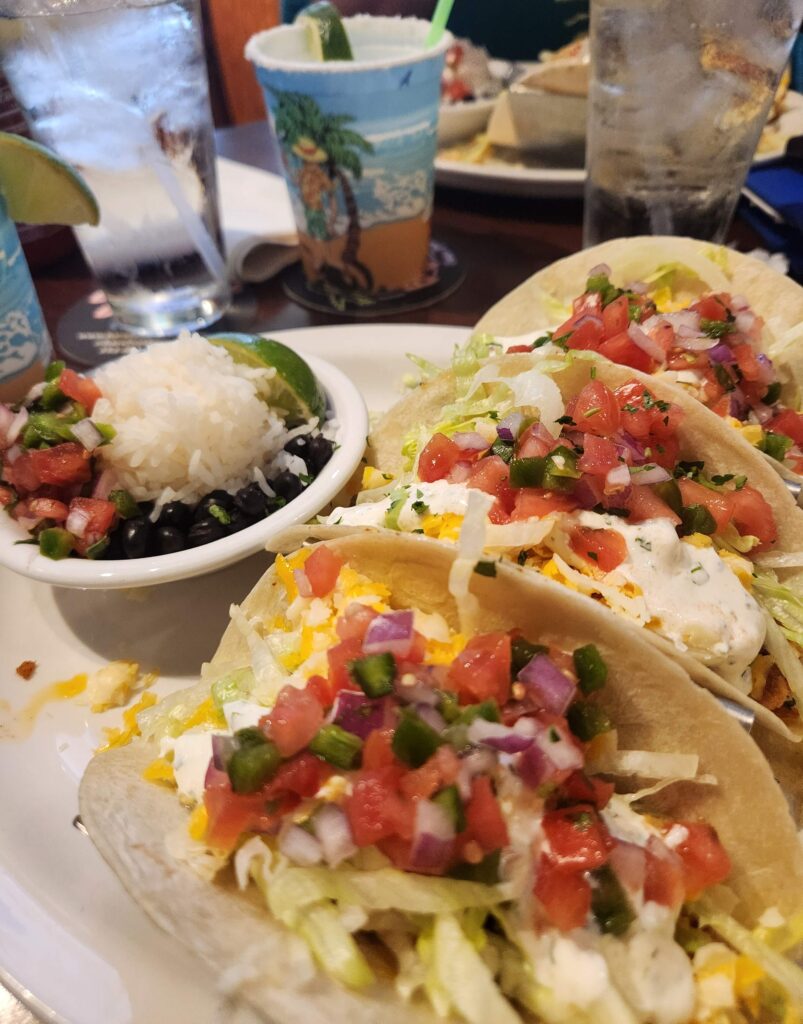three fish tacos with cheese and tomatoes at barefoot bernie's