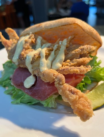 fried crab sandwich with yellow sauce and lettuce