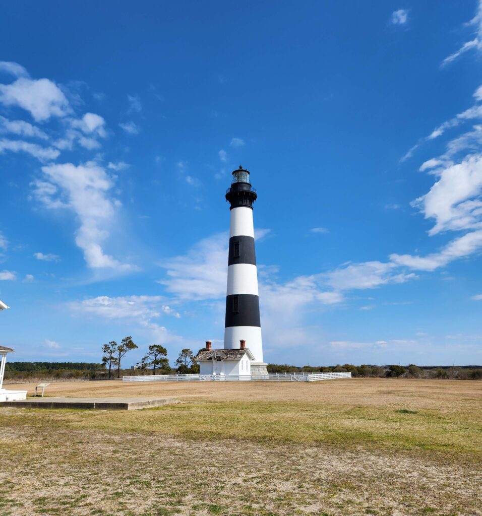bodie lighthouse with white fence around it in the outer banks