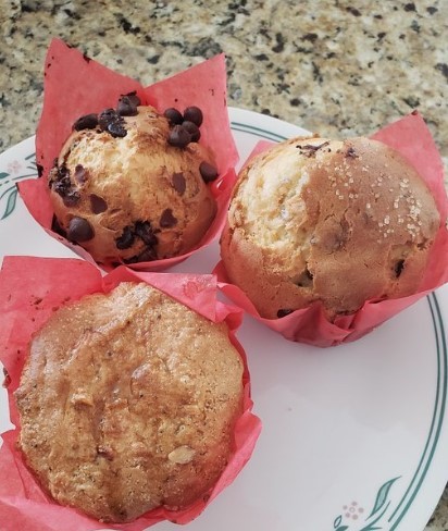 three muffins in red wrapper on a white plate